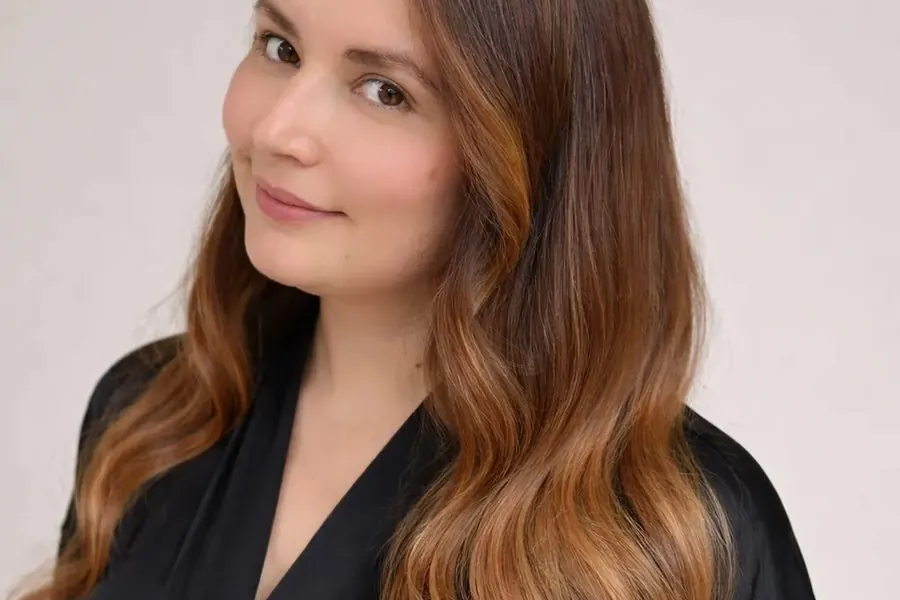 Client with long caramel waves after a blowout